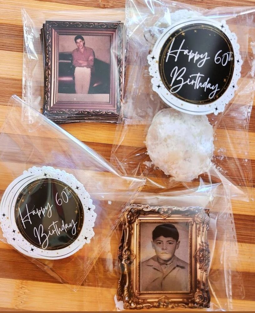 Treat bags sealed with round black and gold Happy 60th Birthday stickers, next to vintage photo stickers in ornate frames